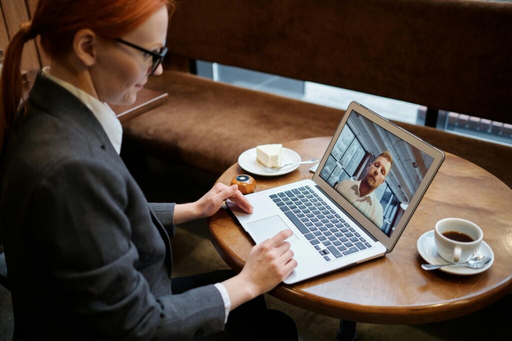 Happy virtual assistant working remotely on a laptop helping a business owner manage AI tools virtually